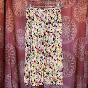 Mid calf length pleated skirt with blue, yellow, pinkpurple, and brown flowers.